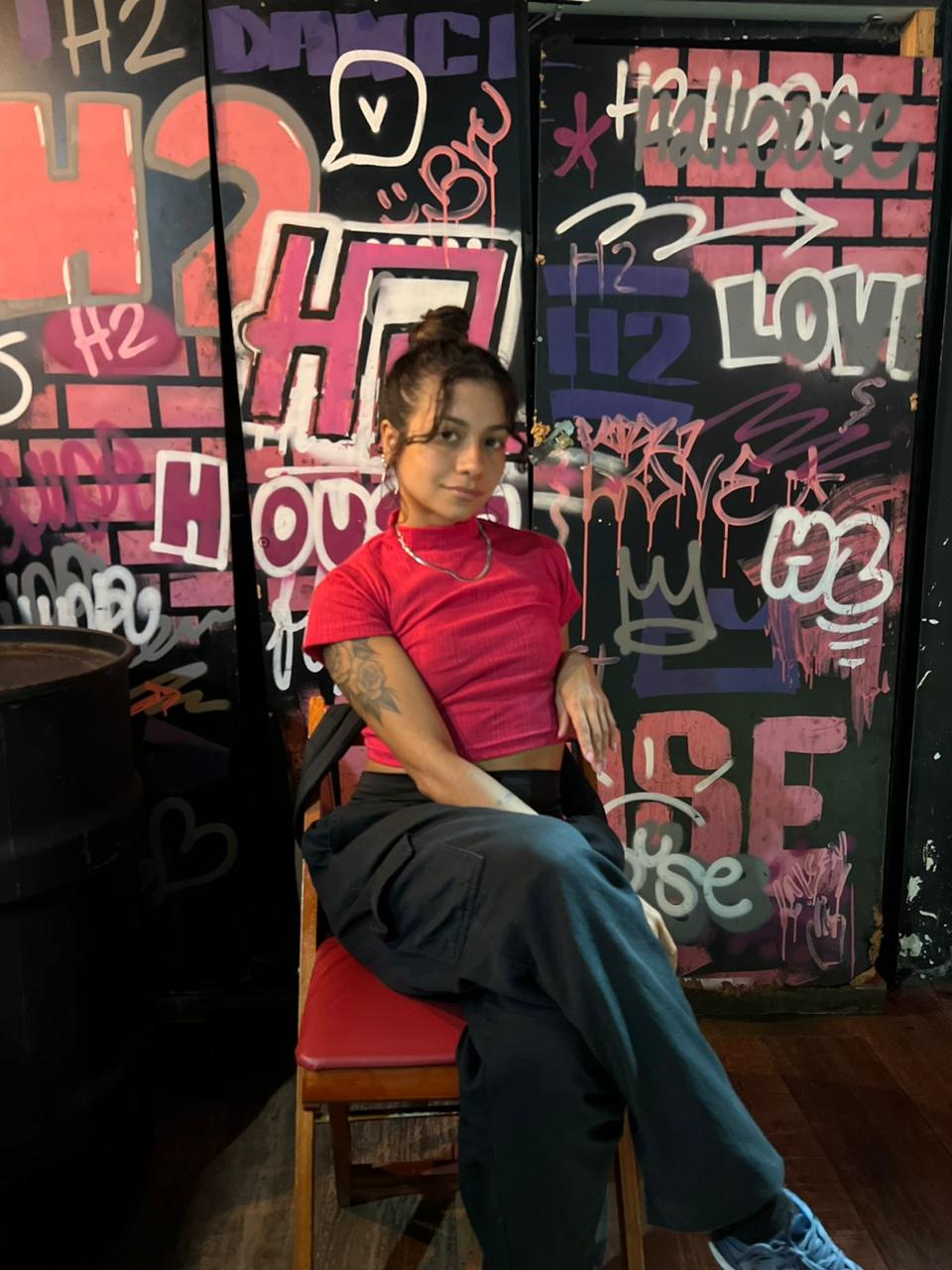 Aluna na frente do graffiti H2